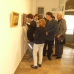 A képen az látható, amint a kiállítás egy képét a látogatócsoportunk körbeállja