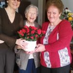 Margitka néninek virágot ad át Fodor Ágnes elnök asszony és Vasné Terike, a harmadik kerületi klub vezetője