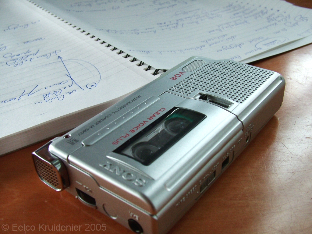 A képen egy diktafon és egy jegyzetfüzet látható