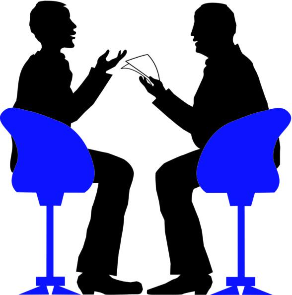Két férfi fekete sziluettje, egyikük papírlapot tart kezében, közben beszélgetnek, a másik fél gesztikulál. Mindketten egy-egy erősen kontrasztos hatású kék forgószékben ülnek.​