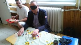 Az egyik vendég egy érzékenyítős játékot próbál ki a családi napon a Piroska Óvodában