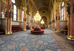 A képen a parlament belső része látható, elegáns kárpitozású székekkel