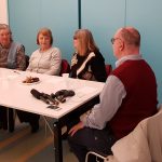 A zuglói klub tagjai a fecske szolgálat bemutatkozását hallgatják egy asztal körül ülve