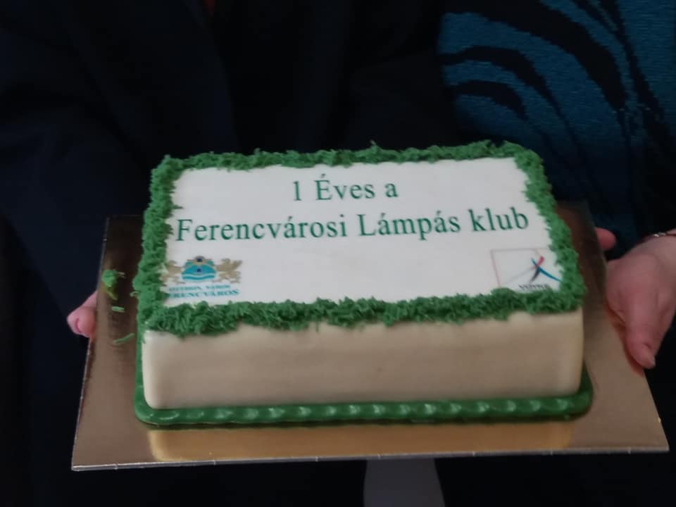 A fotón a születésnapi torta látható: fehér marcipán alapon zöld mintás. Felirata: 1 éves a Ferencvárosi Lámpás Klub.