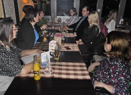 Jobb oldalon középen, szőke hajjal Lengyel Zsófia, mellette fekete öltönyben Németh Dávid ülnek az asztalnál, mellettük és szemben a klub többi résztvevője látható.