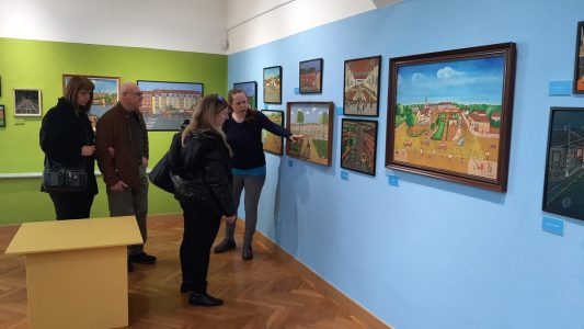 Tárlatvezetés a Pesterzsébeti Múzeumban - a tárlatvezető hölgy a festményeket mutatja be a galériában.