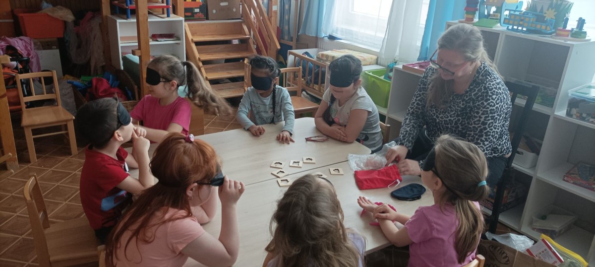 Érzékenyítés a Gyermekkert Tagóvodában - a kicsik a puzzle játékkal játszanak szemtakaró viselése mellett.