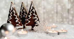 Hangulatos karácsonyi dekoráció (hó, gömb, díszített sütemények, meleg fényű teamécsesek)