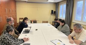 A klub résztvevői asztalok körül ülnek.