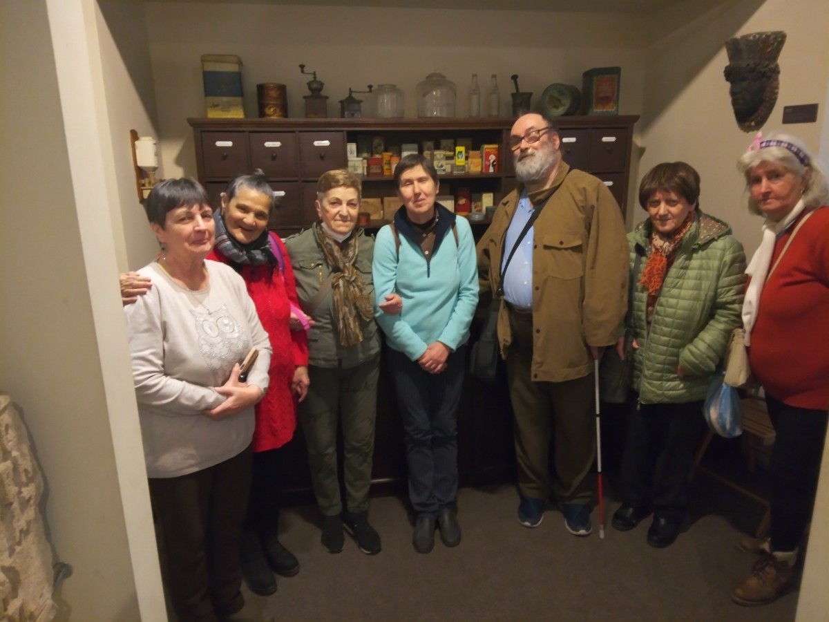 A program résztvevői egy csoportképen az Óbudai Múzeum egy szatócsboltot bemutató tárlója előtt