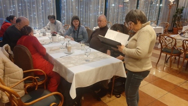 A program résztvevői egy hosszú asztalnál ülnek az étteremben.